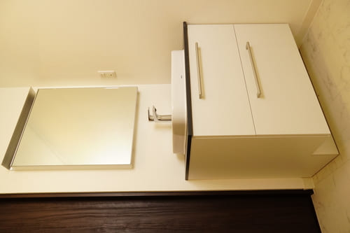 内装工事後の写真 タイルを貼り換え、白と茶色を基調とした洗面台